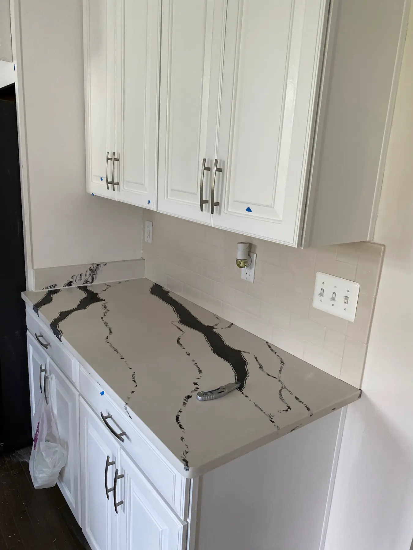 Bold veined stone kitchen backsplash and countertop detail.
