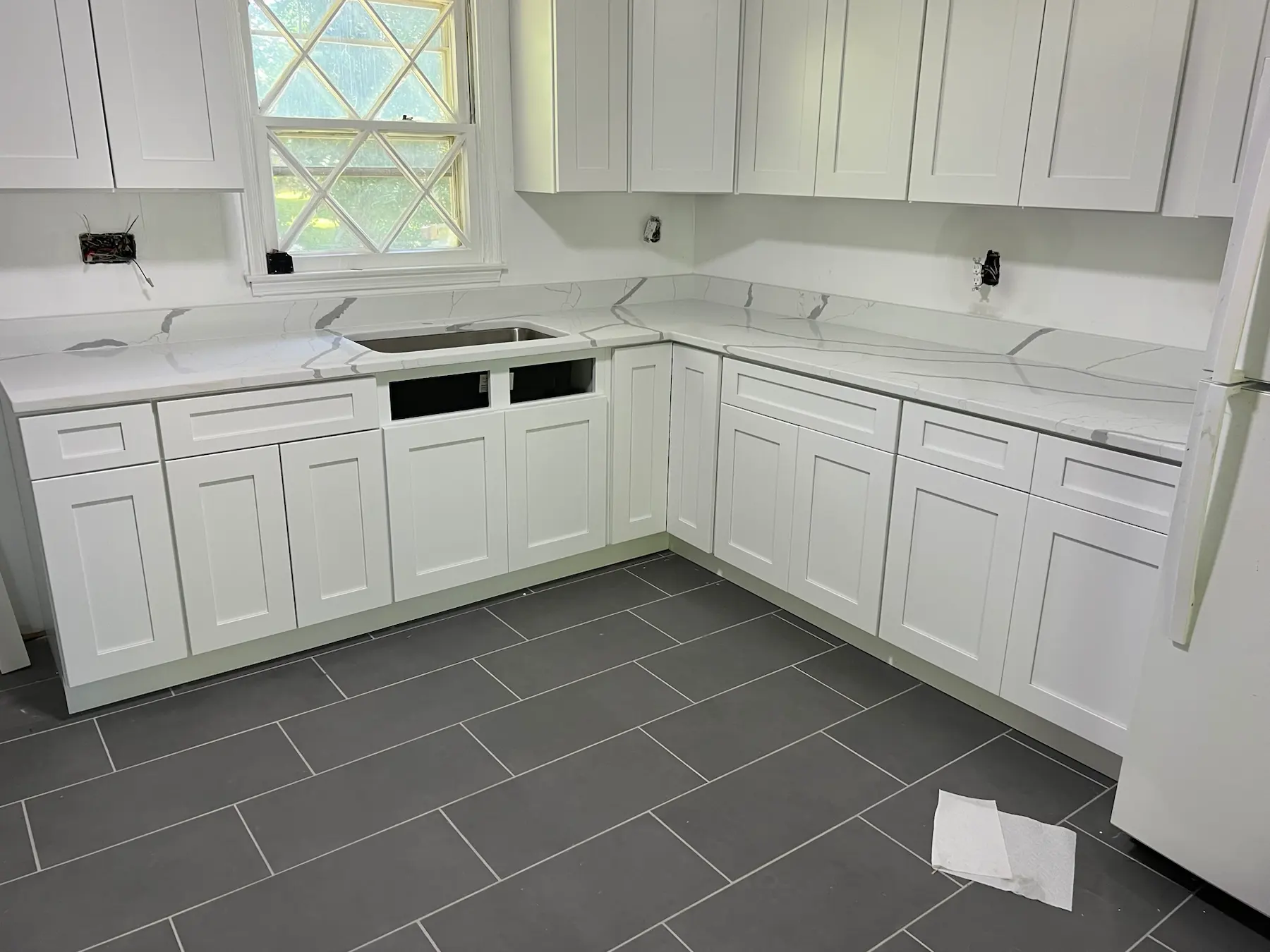 White kitchen countertops with coordinated backsplash in a bright kitchen.