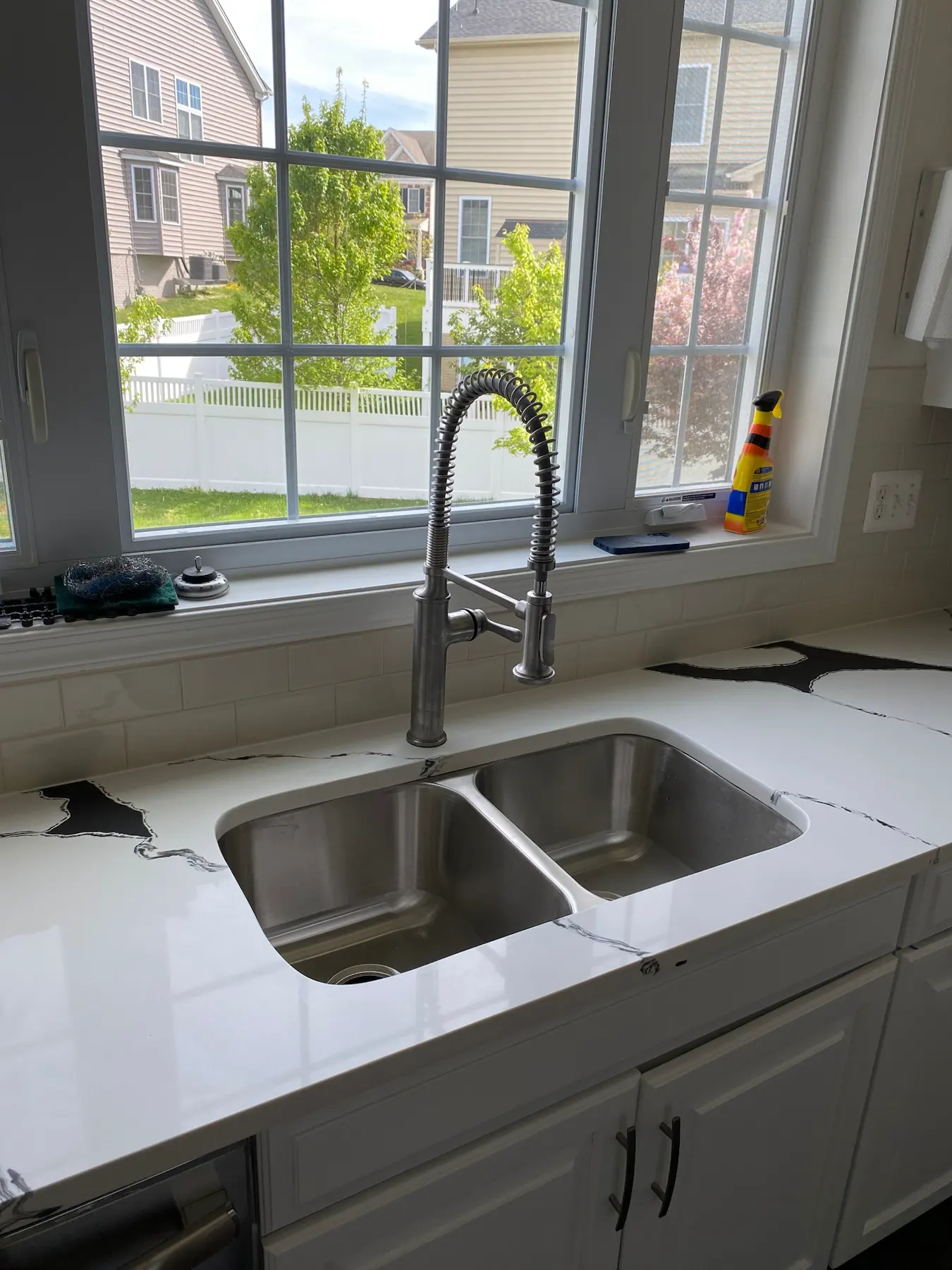 Finished countertop sink cutout detail by a kitchen window.