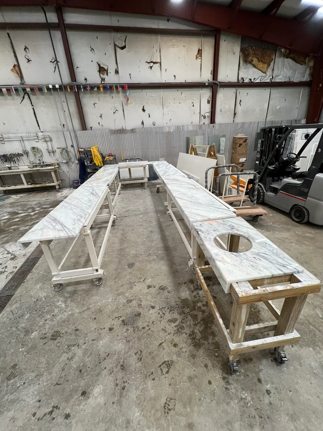 Stone countertop pieces with sink cutouts prepared in the shop.