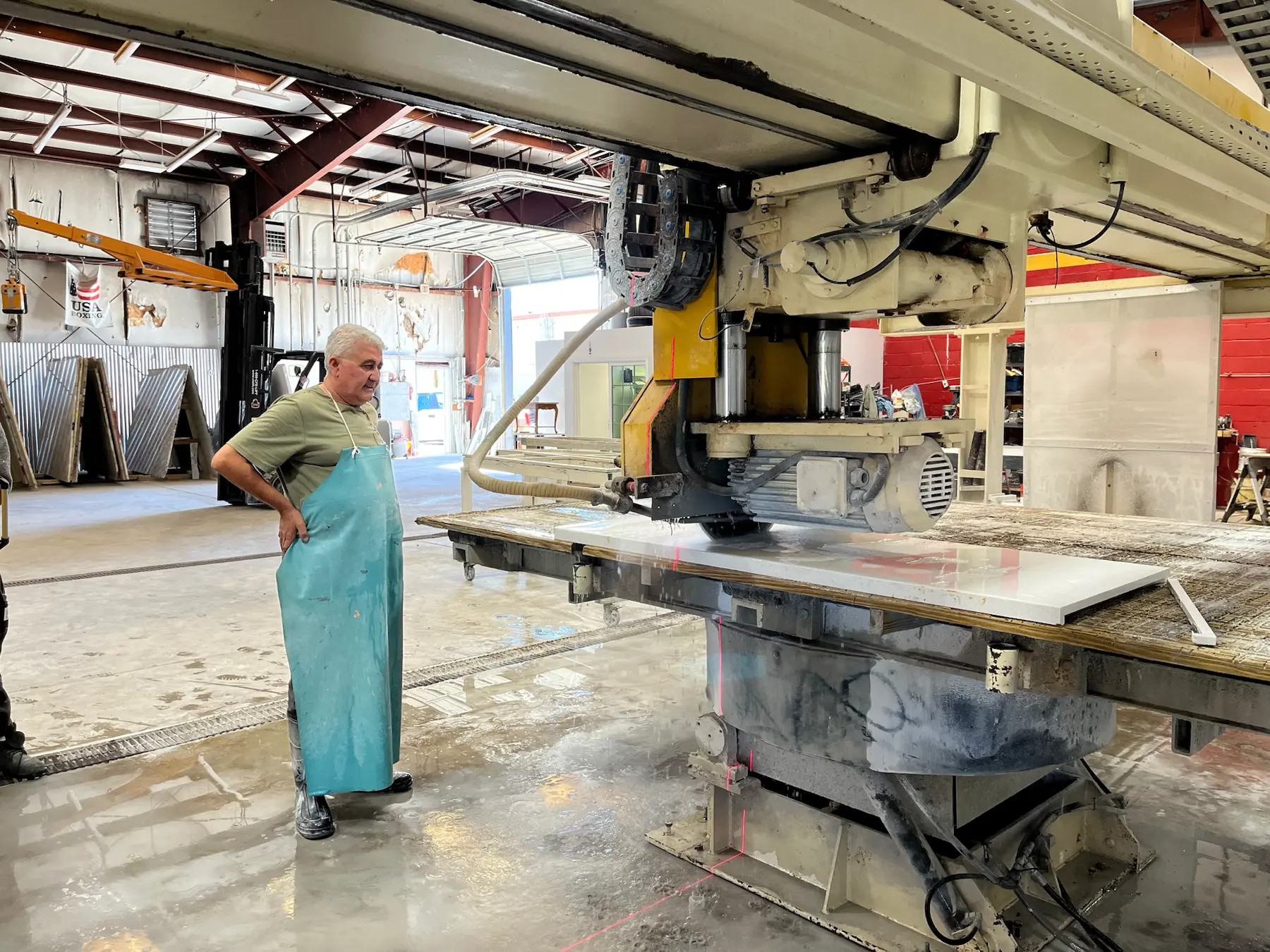 Genova stone fabrication shop with bridge saw and slab work area.