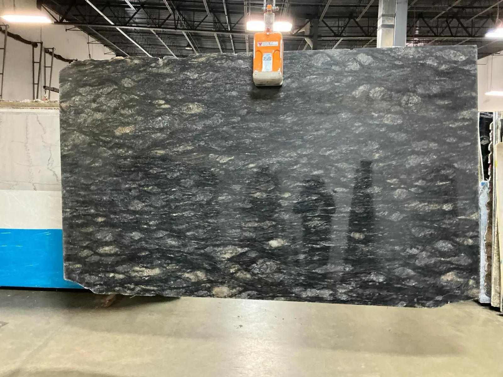 Dark natural stone slab with cloudy movement selected for countertop inspiration.