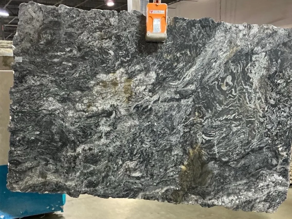 Deep charcoal and silver natural stone slab with sweeping movement.