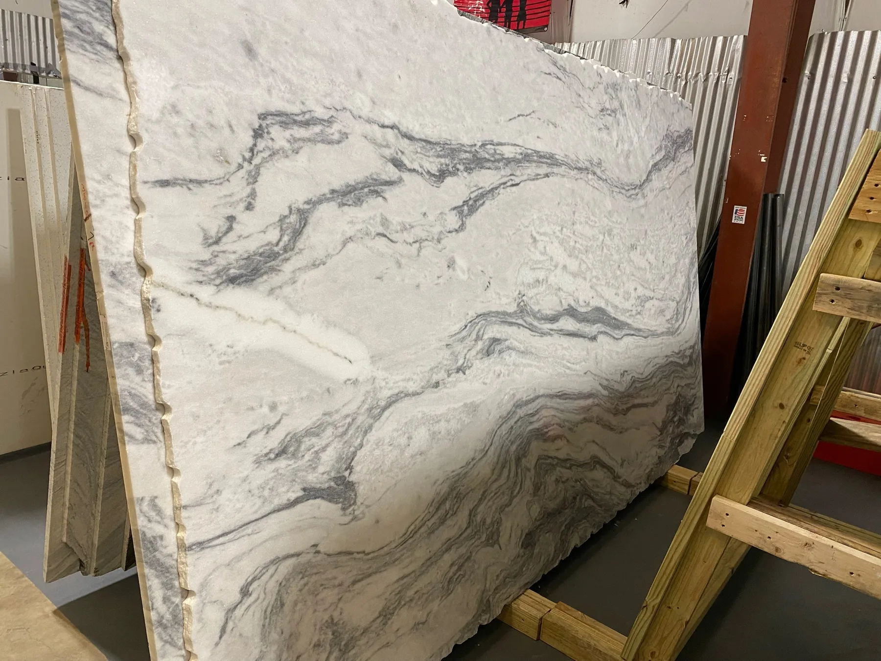 White natural stone slab with dramatic layered gray veining.