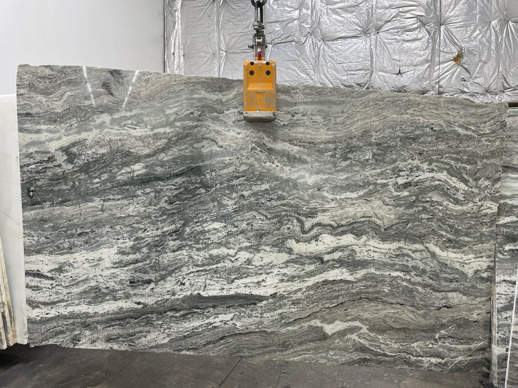 Gray natural stone slab with flowing movement for countertop inspiration.