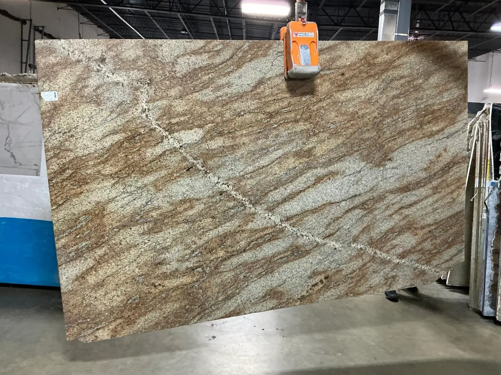 Warm gold natural stone slab with flowing movement for countertop inspiration.
