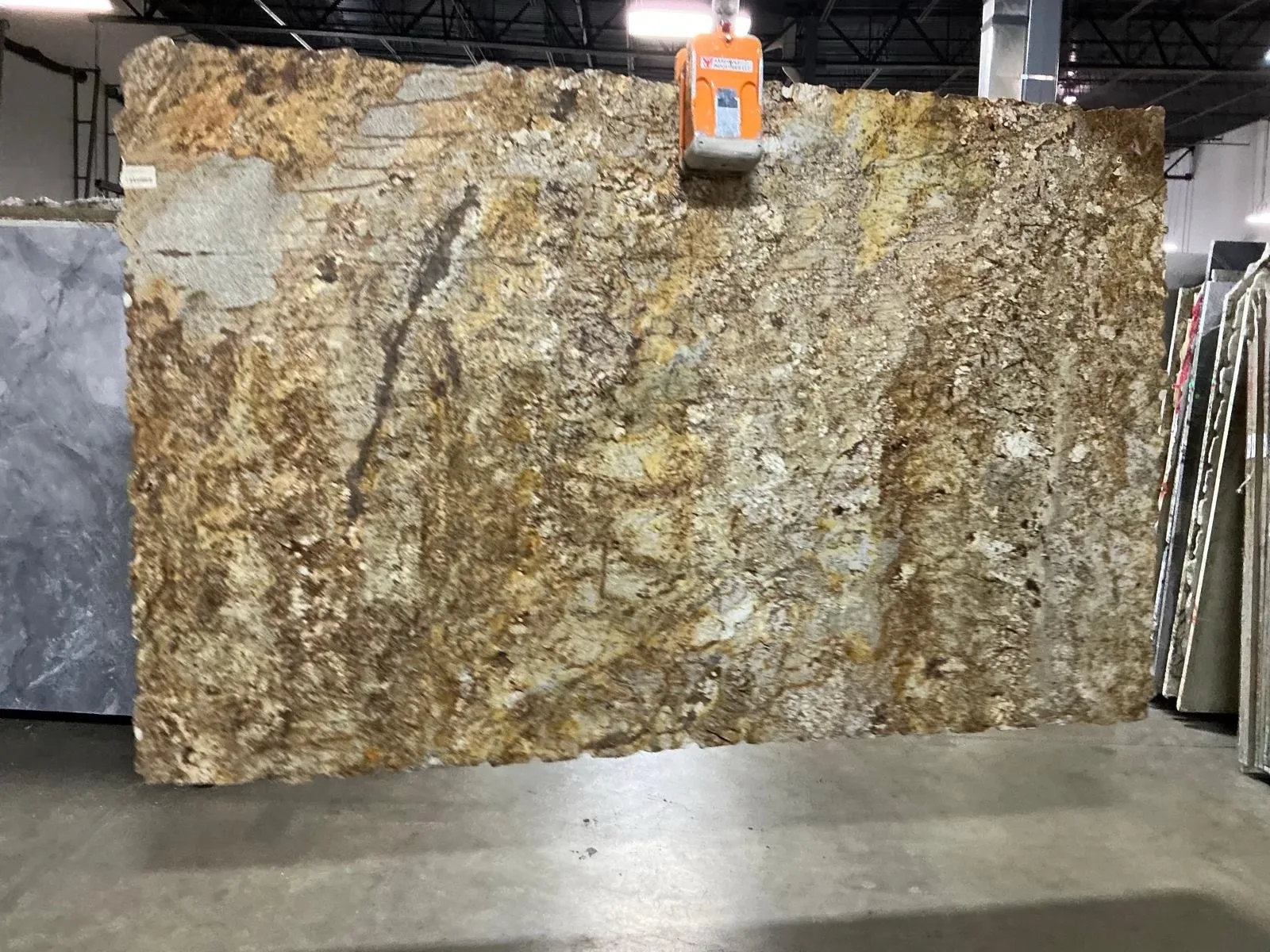 Warm rust, gold, and cream natural stone slab with rich organic movement.
